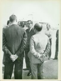 Grupo de pessoas reunido no pátio do Aeroporto de Urubupungá, diante da estação de passageiros.